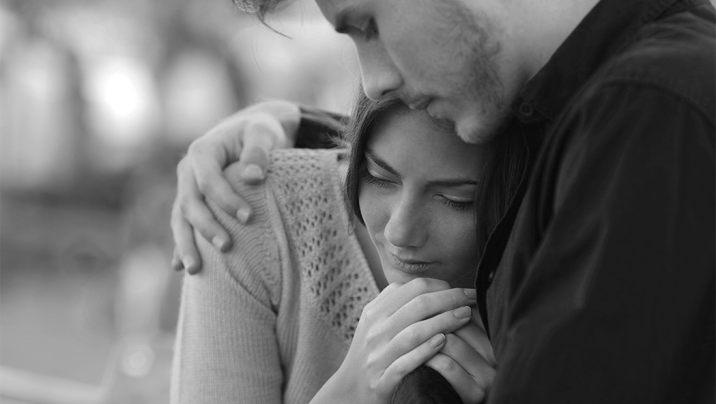 Man comforting his sad mourning partner